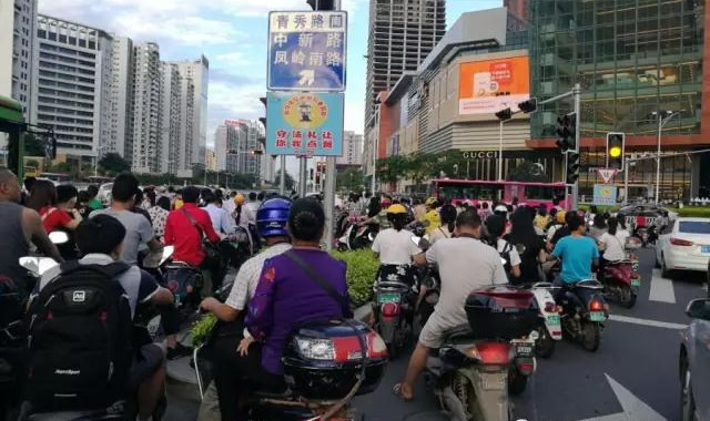 下班晚高峰时间段，民族大道青秀路口排队等候通行的电动自行车